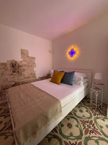 ein Schlafzimmer mit einem Bett mit einer bunten Kugel an der Wand in der Unterkunft Dimore N&N in Polignano a Mare