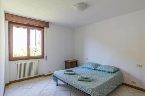 a white bedroom with a bed and a window at Balcone Di Alex & Thomas - Happy Rentals in Val Rezzo