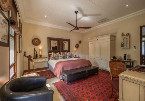 a bedroom with a bed and a red rug at Kambaku River Lodge in Malelane