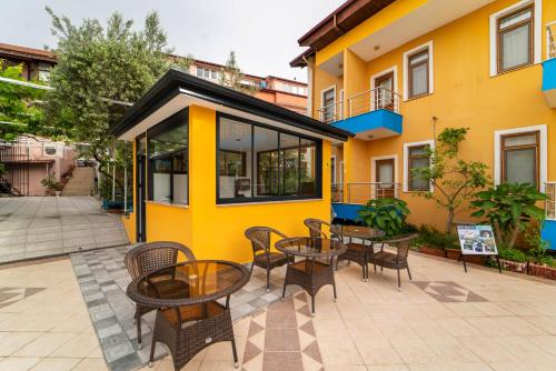 a patio with tables and chairs in front of a yellow building at Suzanne Hotel & Restaurant in Fethiye