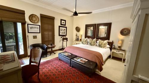 a bedroom with a bed and a chair in it at Kambaku River Lodge in Malelane