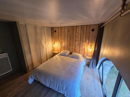 une chambre avec un lit dans une pièce aux murs en bois dans l'établissement Le Lagon Saint Lary 8 pers classé 4 diamants 3 étoiles, à Saint-Lary-Soulan