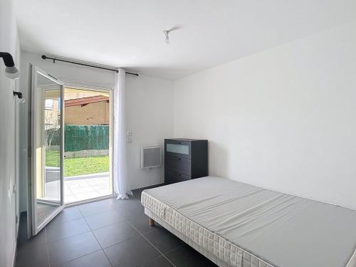 une chambre avec un lit et une porte coulissante en verre dans l'établissement Appartement avec jardin, à Gardanne