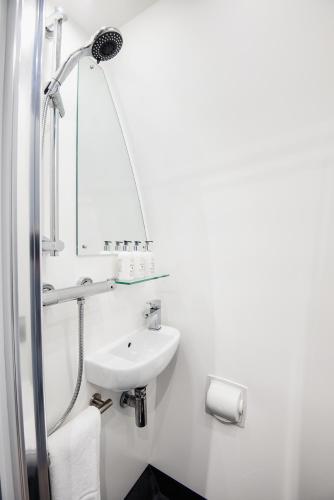 a white bathroom with a sink and a mirror at Peel Farm in Craighall