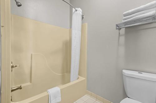 a white bathroom with a shower and a toilet at Days Inn by Wyndham Collinsville St Louis in Collinsville