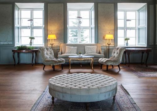 a living room with a couch and a table and chairs at Dragsholm Slot in Hørve