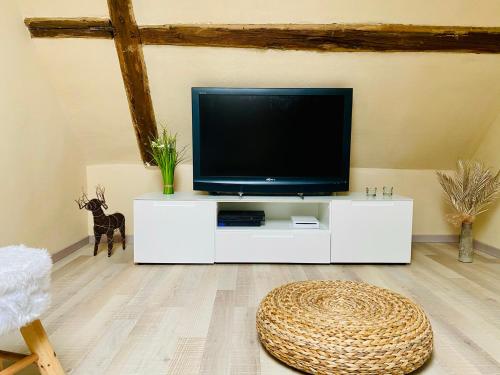 a living room with a tv on a white cabinet at Casa del Sol in Schwaigern