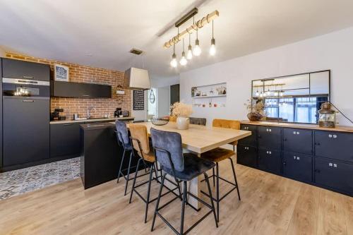 une cuisine avec une table en bois et des chaises bleues dans l'établissement L'Atelier - Plage à 50m et Remparts à 500m, à Saint-Malo
