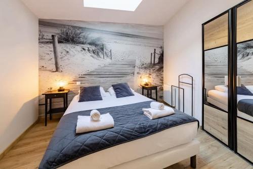 - une chambre avec un lit et une peinture sur la plage dans l'établissement L'Atelier - Plage à 50m et Remparts à 500m, à Saint-Malo