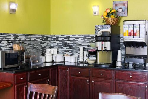 a kitchen with a counter top with a coffee shop at Super 8 by Wyndham South Boston VA in South Boston