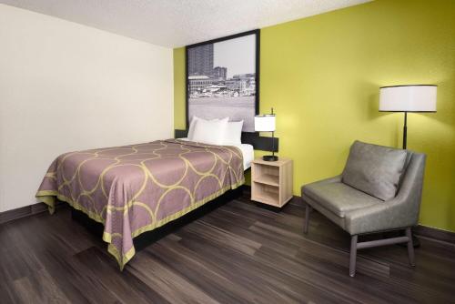 a hotel room with a bed and a chair at Super 8 by Wyndham South Boston VA in South Boston