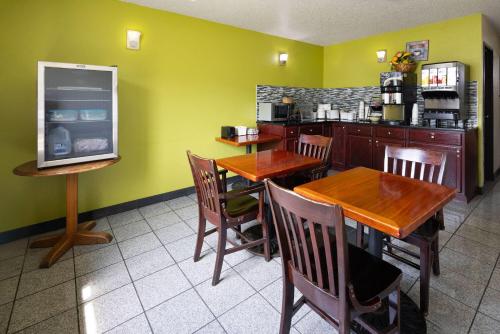 a restaurant with wooden tables and chairs and a kitchen at Super 8 by Wyndham South Boston VA in South Boston