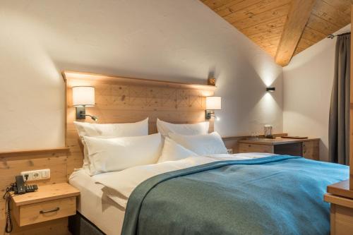 a bedroom with a large bed with white pillows at Hotel Hindenburglinde in Ramsau