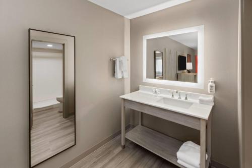 a bathroom with a sink and a mirror at Days Inn by Wyndham Kenner/New Orleans Airport South in Kenner