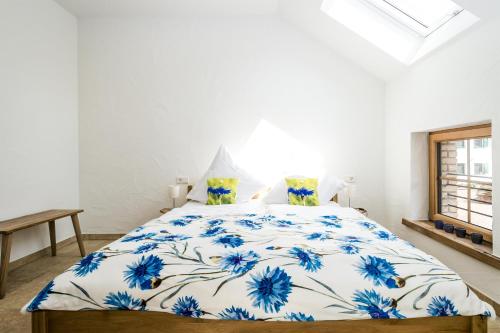 a bedroom with a bed with a blue and white comforter at Hofgut Dösterhof - Hotelzimmer in Wadern