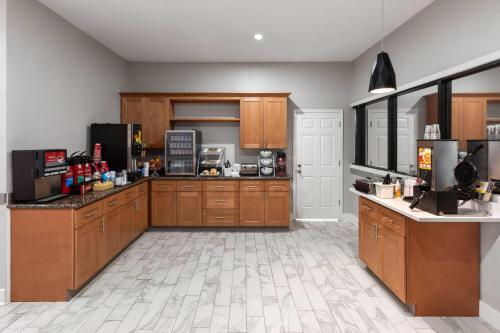 a kitchen with wooden cabinets and a counter top at Days Inn by Wyndham Kenner/New Orleans Airport South in Kenner