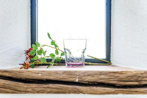 a glass sitting on a window sill with a plant at Hofgut Dösterhof - Hotelzimmer in Wadern