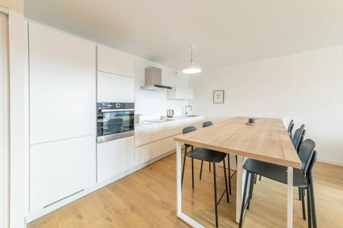 une cuisine avec une table et des chaises en bois dans l'établissement Baudelaire - Beau 2 chambres - Parking/Plage 400m, à Dinard