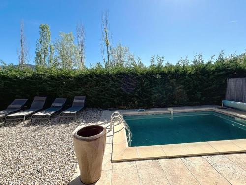 une piscine avec des chaises et un seau à côté dans l'établissement Mazet en pierres pour 6 personnes-3 chambres-piscine, à Puyméras