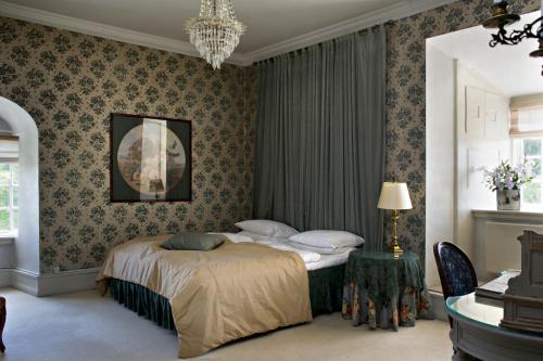 a bedroom with a bed and a chandelier at Dragsholm Slot in Hørve