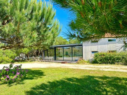 a house with glass windows in a yard at Desertas Beach and Sport in Costa Nova