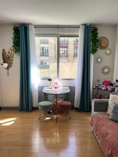 un salon avec une table et une fenêtre dans l'établissement Charmant Studio près des Champs Elysées, à Paris