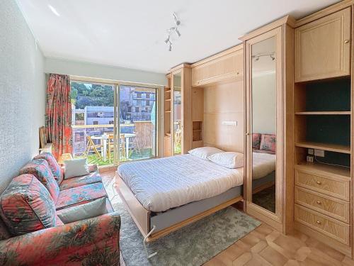 une chambre avec un lit et un canapé dans l'établissement Hello Menton, à Menton
