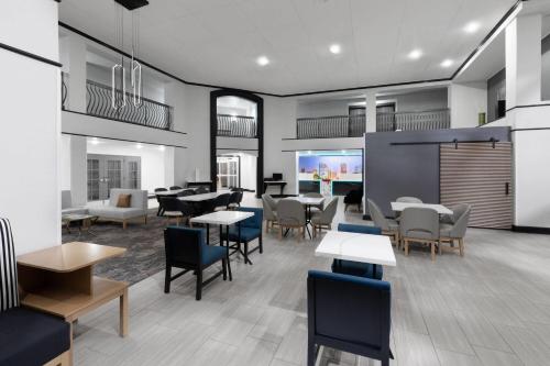a dining room with tables and chairs and tablesktop at La Quinta Inn & Suites by Wyndham Houston Bush IAH South in Houston
