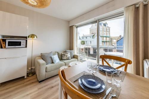 une salle à manger avec une table et un salon dans l'établissement Le Rochebonne - Vue mer - Cosy et rénové - Plage, à Saint-Malo
