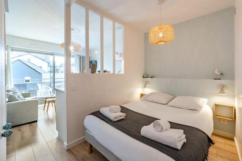 une chambre avec un grand lit avec deux serviettes dessus dans l'établissement Le Rochebonne - Vue mer - Cosy et rénové - Plage, à Saint-Malo