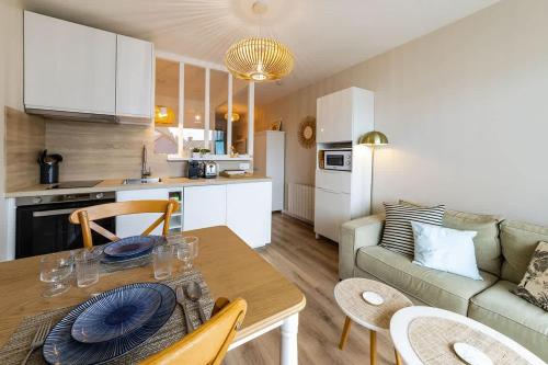 une cuisine et un salon avec une table et un canapé dans l'établissement Le Rochebonne - Vue mer - Cosy et rénové - Plage, à Saint-Malo
