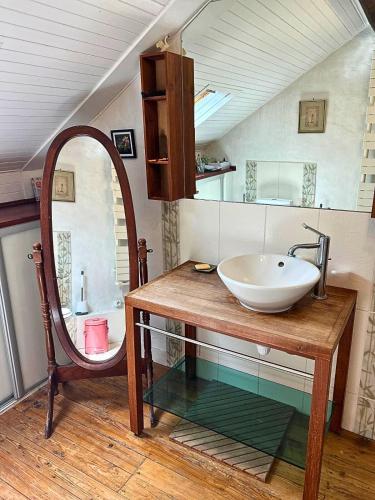 une salle de bain avec un lavabo et un miroir dans l'établissement Maison tout confort proche Disneyland avec Jardin, BBQ & parking privé, à Esbly