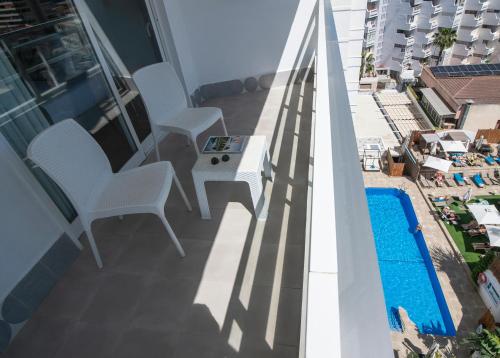 a balcony with chairs and a table and a swimming pool at Hotel Costa Málaga - Adults Recommended - by Pierre & Vacances in Torremolinos
