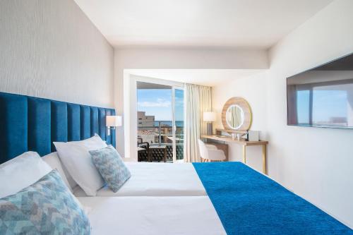 a hotel room with a bed with a blue headboard at Hotel Costa Málaga - Adults Recommended - by Pierre & Vacances in Torremolinos
