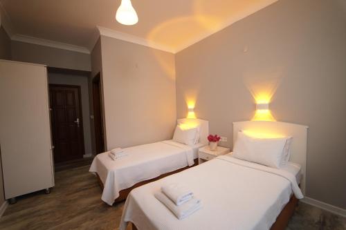 two beds in a room with lights on the wall at Suzanne Hotel & Restaurant in Fethiye