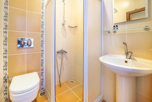 a bathroom with a toilet and a sink and a shower at Suzanne Hotel & Restaurant in Fethiye