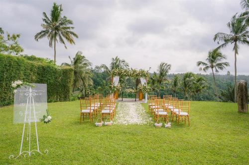 a wedding ceremony on the lawn at a resort at Alila Ubud in Ubud