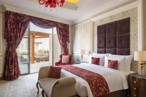 a bedroom with a large bed and a chair at Marsa Malaz Kempinski, The Pearl in Doha