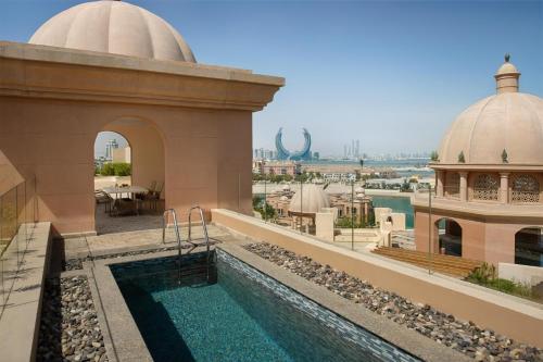 a swimming pool on the roof of a building at Marsa Malaz Kempinski, The Pearl in Doha