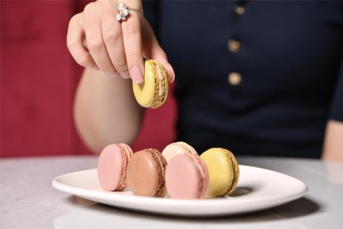 a person holding a banana over a plate of desserts at Marsa Malaz Kempinski, The Pearl in Doha