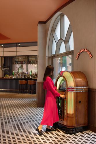 a woman in a red dress standing next to a treasure chest at Marsa Malaz Kempinski, The Pearl in Doha