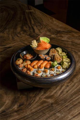 a plate of sushi and vegetables on a table at Marsa Malaz Kempinski, The Pearl in Doha
