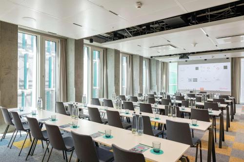 a room with rows of tables and chairs at nhow Frankfurt in Frankfurt/Main