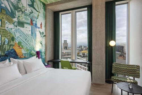 a bedroom with a bed and a large window at nhow Frankfurt in Frankfurt/Main