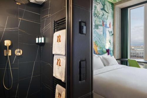 a hotel room with a bed and a shower at nhow Frankfurt in Frankfurt/Main