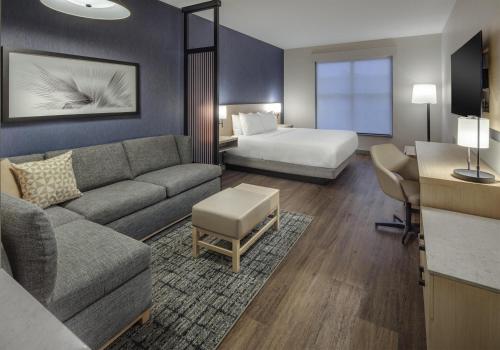 a hotel room with a couch and a bed at Hyatt Place Newark-Main Street in Newark