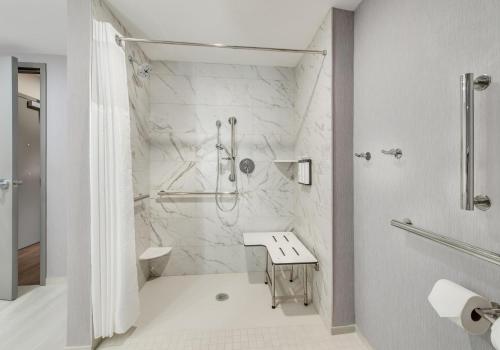 a white bathroom with a shower and a sink at Hyatt Place Newark-Main Street in Newark