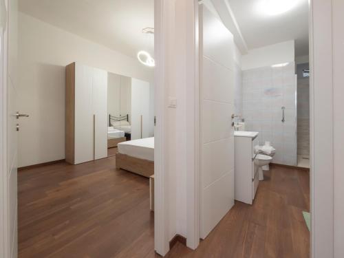 a white bathroom with a bed and a sink at I-Host Apartment - Cesarotti 2 in Milan