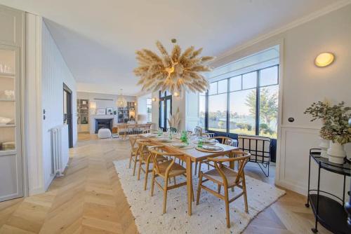 une salle à manger avec une table, des chaises et un lustre dans l'établissement Villa Émeraude -Maison d'exception-Piscine-Jacuzzi, à Saint-Malo