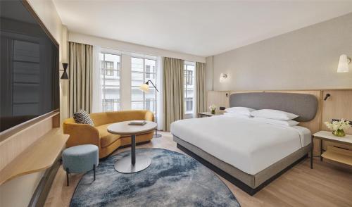 a hotel room with a bed and a couch and a table at Hyatt Regency London Blackfriars in London